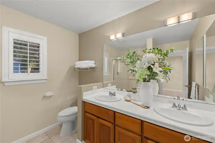 Primary bath featuring dual vanities and tiled floor
