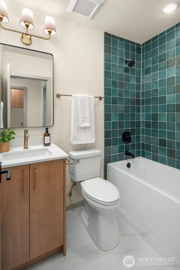 Luxurious bathroom retreat featuring a custom walk-in shower with vibrant teal tiling and modern fixtures.