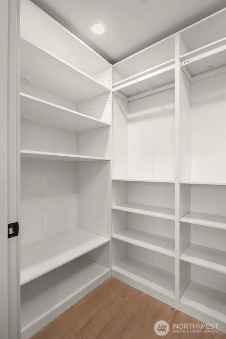 Custom-built storage room with extensive shelving, ideal for use as a large pantry or linen closet.