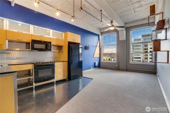 The open floor plan creates an easy flow for relaxing, cooking, dining, and entertaining. Original ceilings painted white, thoughtfully chosen finishes, and plush carpeting make this space feel comfortable and inviting.