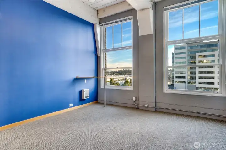 Floor-to-ceiling windows flood the living room with natural light and frame scenic views of the city, Thea Foss Waterway, and Mt. Rainier.
