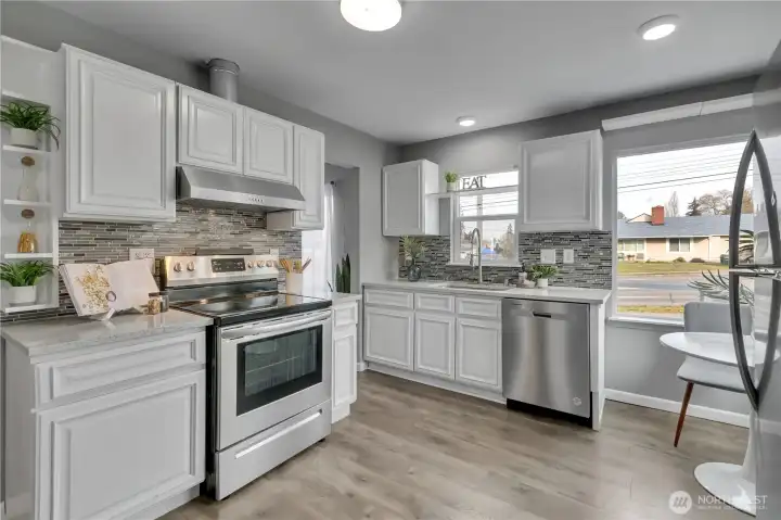 Updated kitchen with beautiful white cabinetry, designer tile backsplach & stainless appliances!