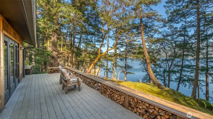 Late afternoon on the original composite deck; owner added cedar bench with firewood storage. Two cords of firewood included.