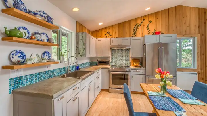 New cabinets, concrete counters, sink/faucet, glass tile mosaic backsplash and appliances. The range is standard smoothtop, not induction.