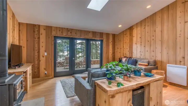 The kitchen/living area has two skylights to bring in natural light. The woodstove has a new concrete hearth that matches the concrete kitchen counters.