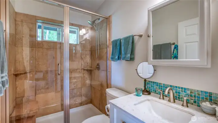 New vanity, toilet, faucets and accessories. Glass mosaic backsplash matches kitchen, adding a nice burst of color.