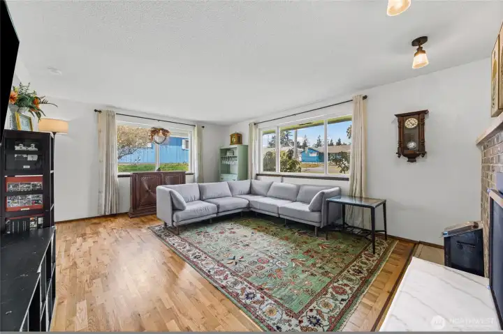 The spacious living room  get lots of natural light.  Notice the beautiful wood flooring.