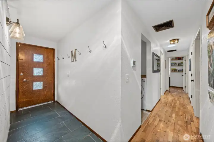 Hallway view off of foyer. Two solar tubes in the hallway, the laundry room/owner entry is first opening on the left, with the two guest bedrooms and primary with en-suite, full guest bath and linen closet.
