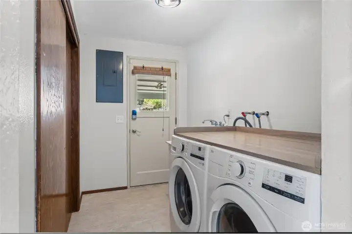 The laundry room with utility sink and wall-to-wall storage closet.   The door is the owners entry from the carport.