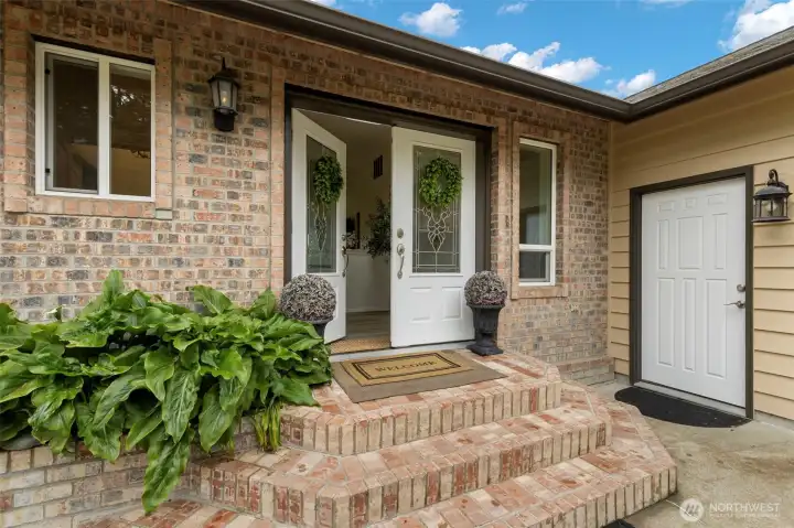 A refined brick entry welcomes you into this luxury Kitsap County home, where timeless craftsmanship, elegant,and warm Pacific Northwest charm create an elevated first impression. Thoughtful details, lush landscaping, and a gracious front entrance set the tone for sophisticated living on private acreage in Port Orchard.