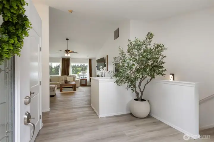 A bright, refined entryway welcomes you into this luxury Kitsap County home, showcasing fresh interior paint, new wide-plank flooring, natural light, and a seamless flow into the living space for elevated Port Orchard living.