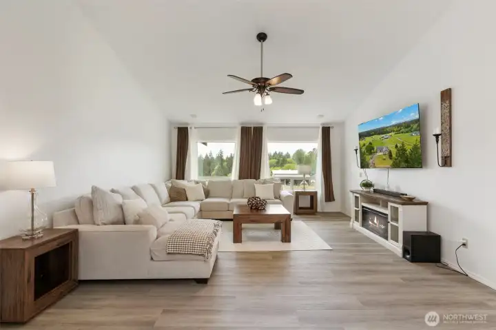 Luxury open-concept living room in Port Orchard featuring vaulted ceilings, natural light, spacious design, and serene acreage views—crafted for comfort, elegance, and elevated living.