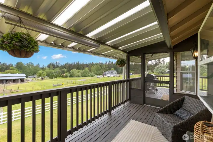 Expansive covered deck with panoramic pasture views, equestrian amenities, and refined outdoor living for relaxing or entertaining.
