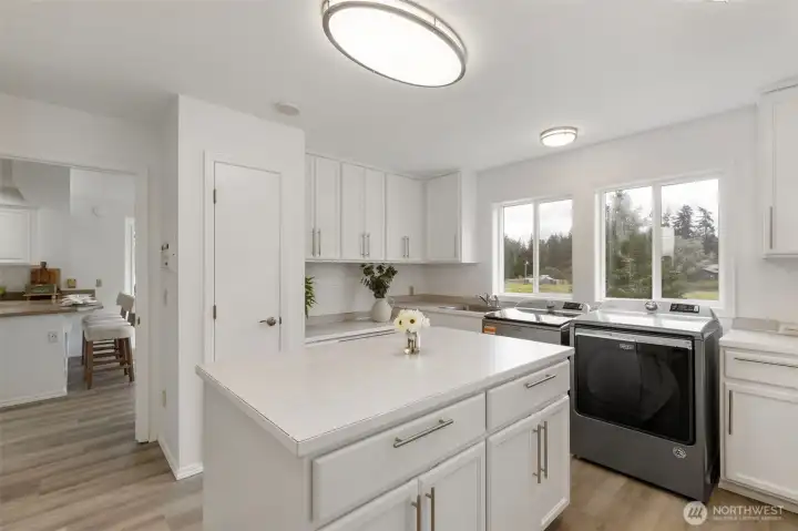 Spacious laundry room with abundant cabinetry, generous folding space, natural light, and peaceful acreage views, designed for elevated everyday function and refined home organization.