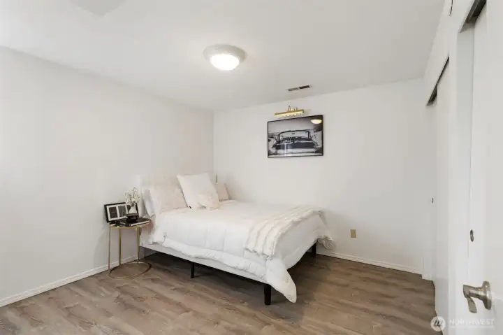 Comfortable third downstairs bedroom with clean finishes and warm flooring.