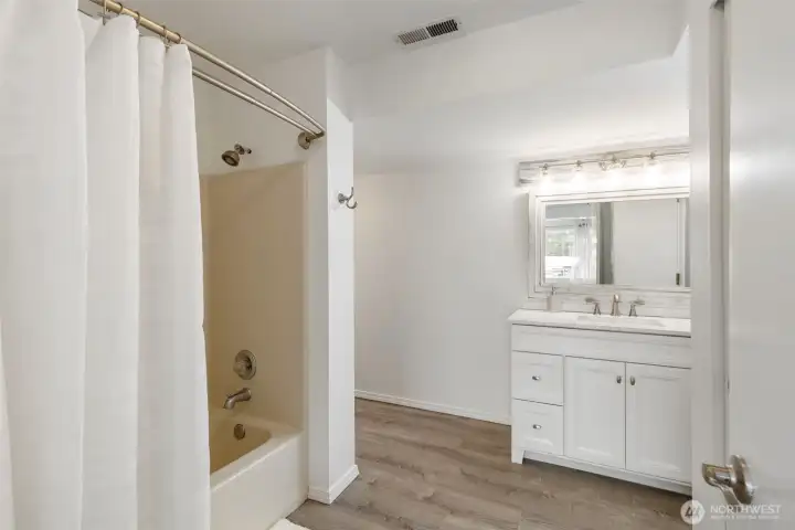 Downstairs full bathroom with a bright vanity, clean finishes, and convenient tub/shower combination, designed for comfort, function, and easy guest living.