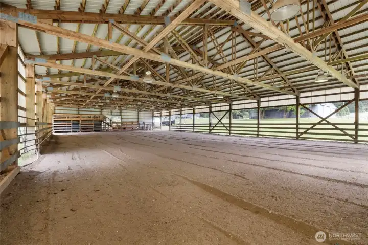 Expansive covered arena with lighting and a new wood deck for entertaining—ideal for year-round riding, training, gatherings, and elevated equestrian living.