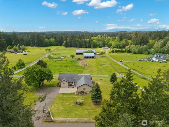 Nearly 10 fully fenced acres in Port Orchard with a luxury home, open pastures, equestrian amenities, mature trees, and sweeping Pacific Northwest views.