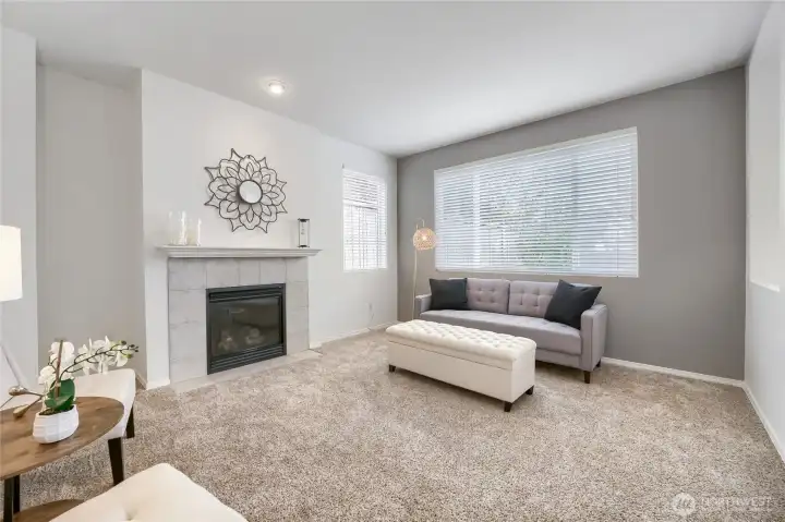 Spacious family room with gas fireplace & a large window overlooking the private backyard