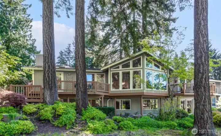 Exquisite golf course setting framed by towering evergreens, floor to ceiling windows, and multiple entertaining decks. Beautiful Northwest living at its finest. (Back of the home)