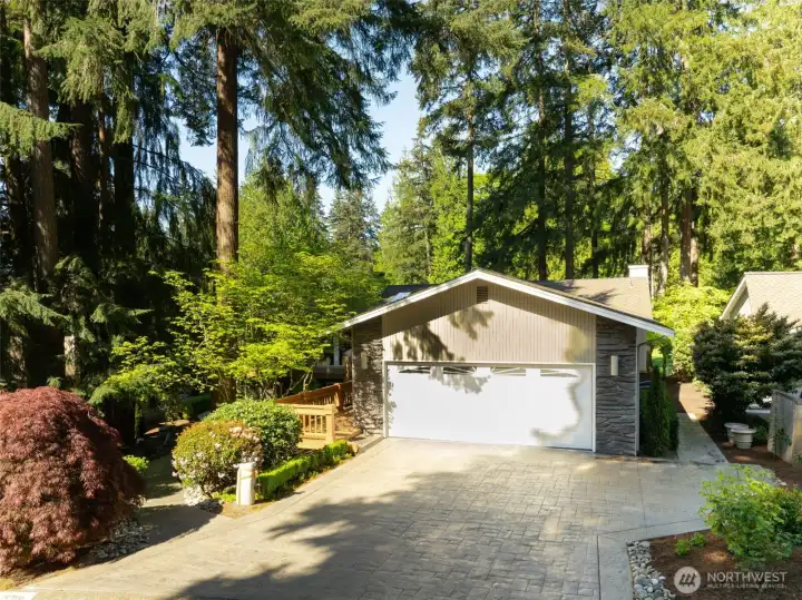 This amazing home offers a striking arrival with timeless stone accents, large light fixtures, lush landscaping, in a peaceful, private setting.