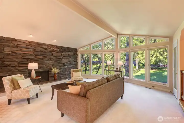Light and bright floor-to-ceiling windows and a striking stone fireplace wall anchor the vaulted living room, overlooking the gorgeous golf course setting.