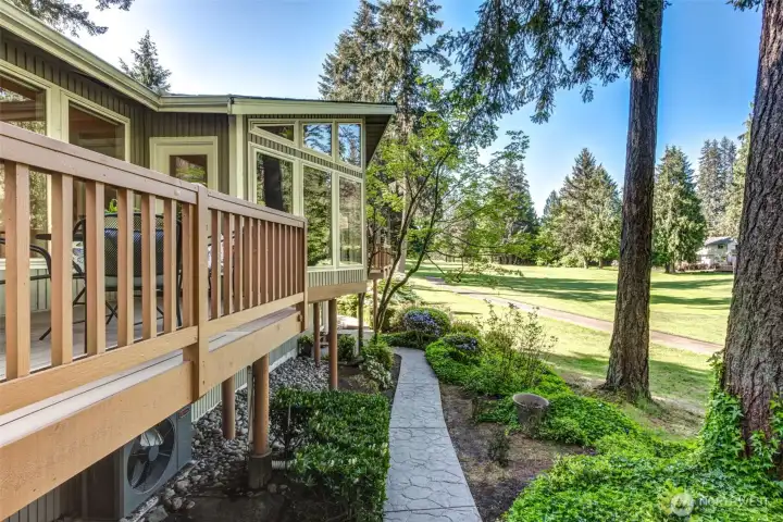Landscaped pathway and tiered outdoor spaces create a seamless connection between the covered patio, elevated decks, and the pathway to the front of the home. All with a golf course backdrop.