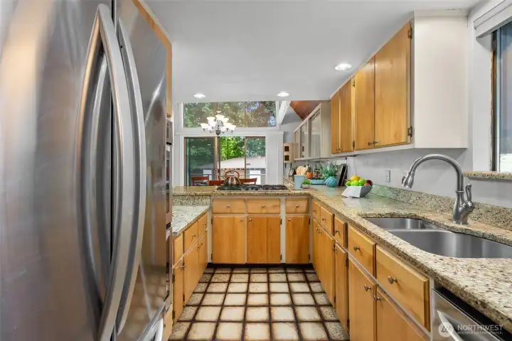 Kitchen with solid wood cabinets and granite counters with a view of the dining space and beyond.  Great for enjoying conversation from the kitchen.