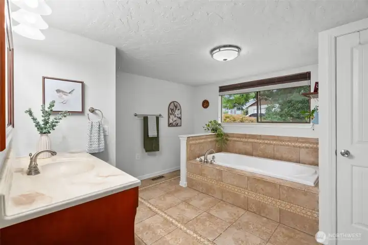 Downstairs full bath features a separate tiled shower and huge soaking tub.