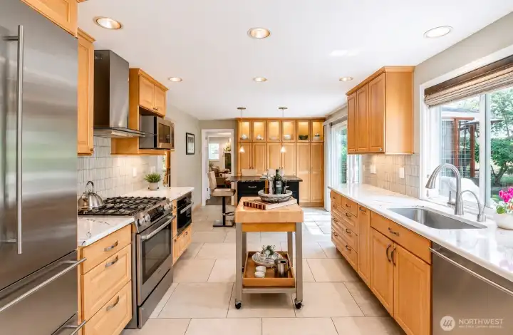 Gourmet kitchen with custom cabinetry, Cambria quartz countertops, Through-color heated tile floors, professional appliances and versatile center island.