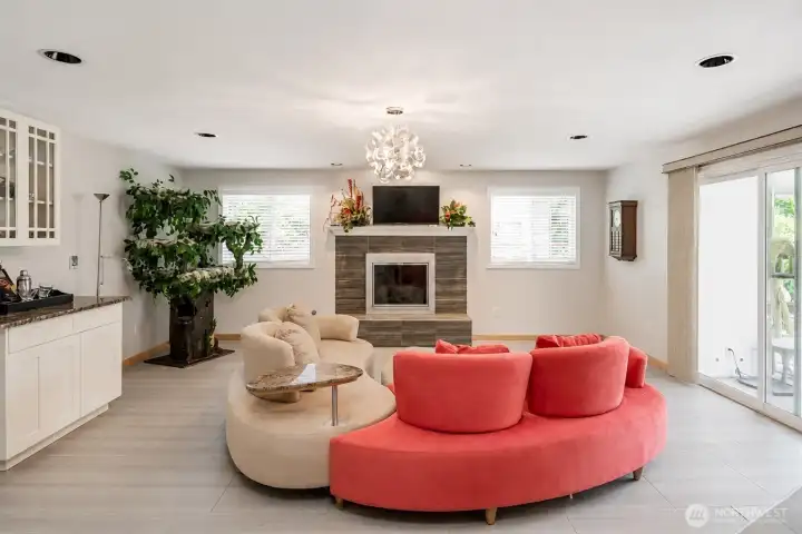 Spacious family room featuring Through-color heated tile flooring, custom built-in cabinetry and direct access to the sunroom.