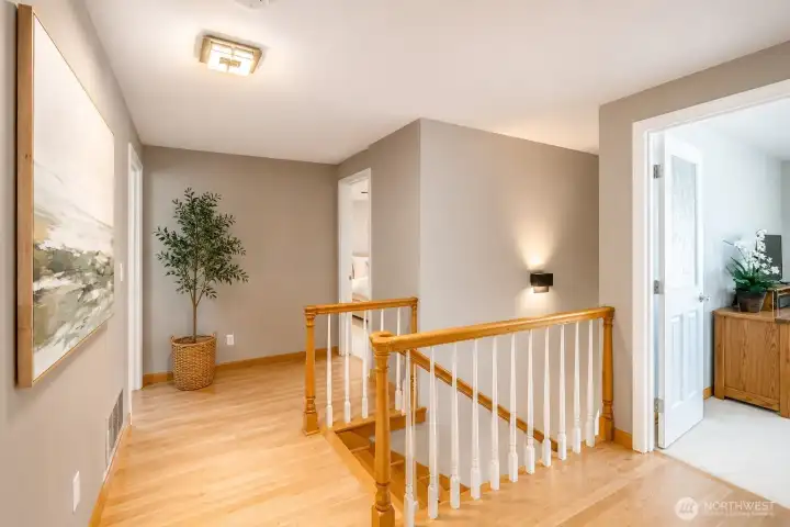Elegant upstairs landing with hardwood floors and custom decorative glass doors adding both character and architectural appeal.