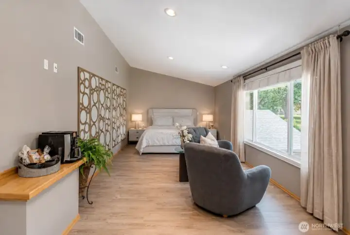 Rare oversized primary suite with room for both a luxurious bedroom and private sitting area. Large windows fill the space with natural light.