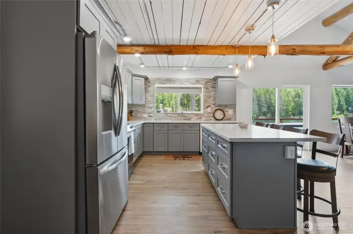 Fully updated kitchen with new cabinets, quartz countertops, stone backsplash and stainless-steel appliances.