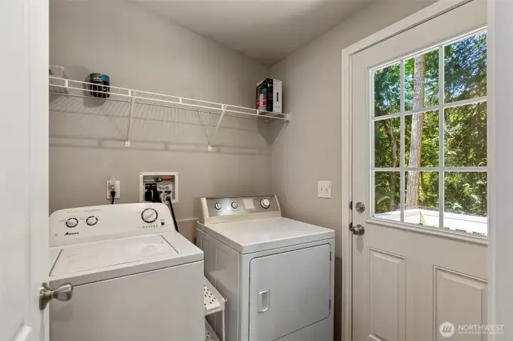 Laundry room off kitchen with exterior door.