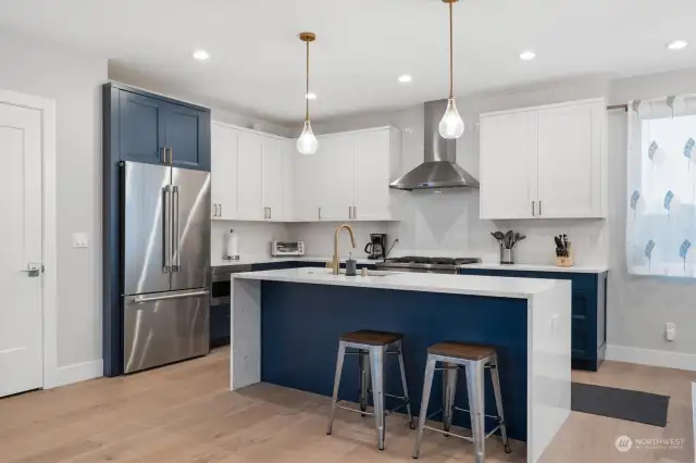 Huge, beautiful open gourmet kitchen with an island that also serves as a sitting bar! Gorgeous custom cabinets – no storage problem here, there are tons of cabinets! Quartz countertop and ceramic tile backsplash. Top of the line stainless steel appliances.  This kitchen was built for cooking and entertaining!