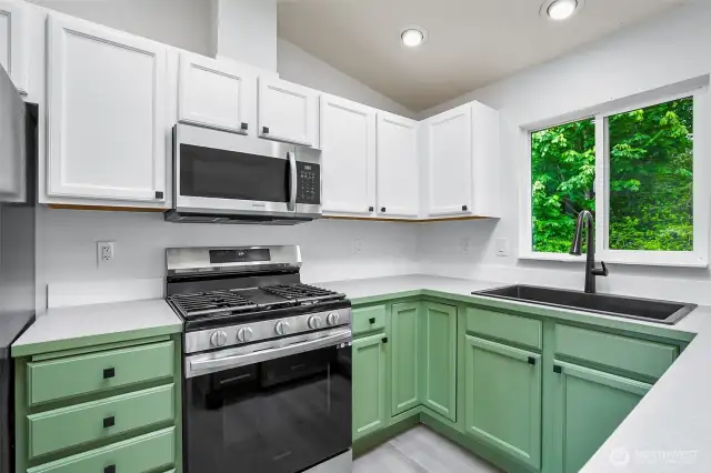 Stainless steel Samsung appliances, quartz-style countertops, matte black fixtures, and shaker cabinetry with a fresh two-tone design.
