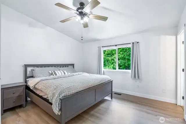 Bright and private primary bedroom with large window overlooking the backyard and greenbelt.