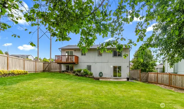 Private, fully fenced backyard with elevated deck and patio. Spacious and tree-lined with room to entertain, garden, or play.
