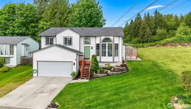 Crisp exterior with 2025 roof, fresh landscaping, and a green front door. Located on a spacious corner lot with side yard.