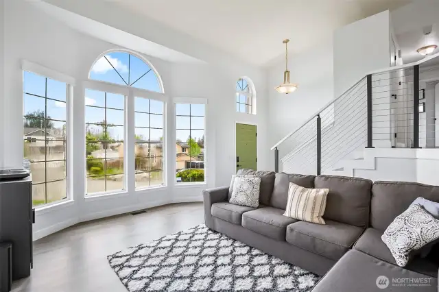 Open-concept design with soaring ceilings, oversized windows, and direct flow to upper and lower levels. Flexible living space with modern finishes.