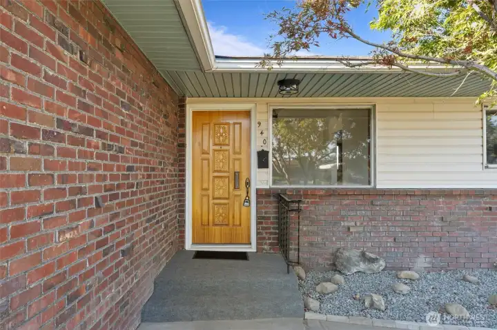 Classic brick and a carved solid wood front door make a statement at the front entry.