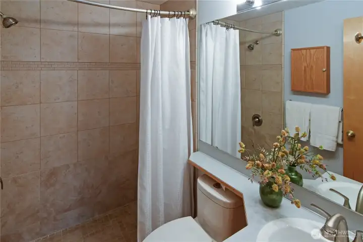 Primary bathroom featuring a walk-in tile shower and clean, updated finishes — a comfortable and practical ensuite for everyday living.