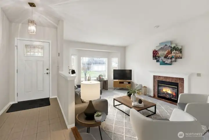 Entryway and living room with a lot of light and gas fireplace. Virtually staged.