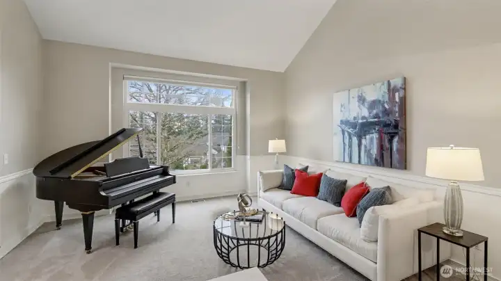 Large windows, vaulted ceilings, and newer carpet highlight this space