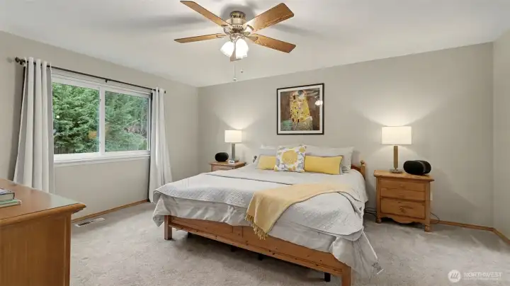 Spacious primary suite showcases tranquil views of the backyard