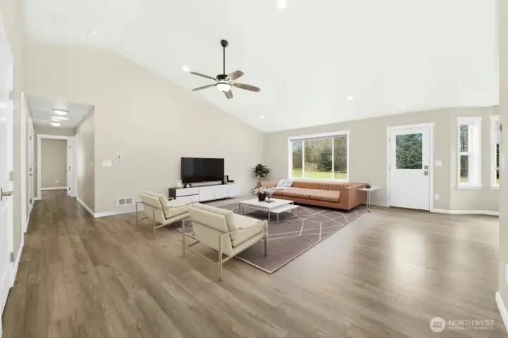 View from entry to living room. Vaulted ceiling with ceiling fan and ductless mini split A/C. HW Floor throughout.  Virtual staged.