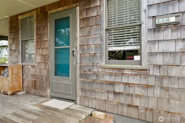 covered front porch protects you from the elements. Shingle siding adds coastal charm.
