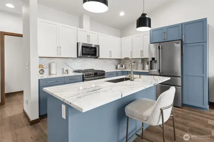 Stunning updated kitchen featuring quartz countertops, a large island, and a gas range, ideal for both entertaining and everyday living.