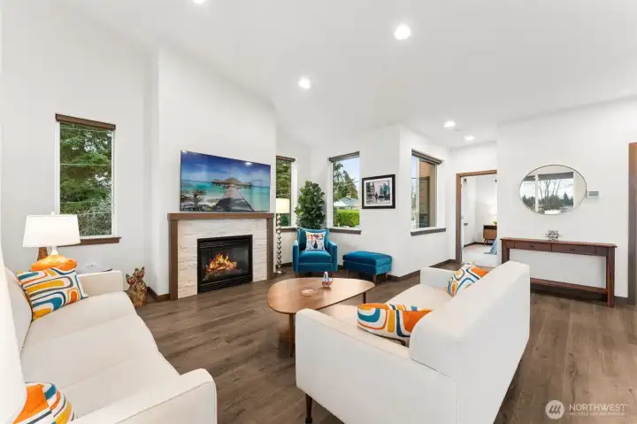 Open living area featuring vaulted ceilings and a cozy gas fireplace.
